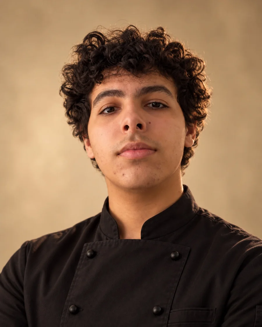 Portrait de Rayan en veste de cuisine noire